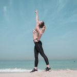 Woman Pointing at Sky on Seashore